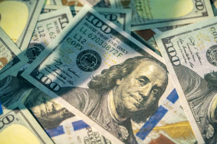 Close-up of benjamin franklin on scattered one hundred dollar bills